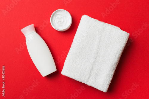 Cosmetic shampoo bottle mockup with towels on a colored table. Bathroom background, toilet accessories for hand and body care
