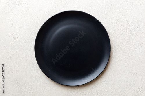 Top view of black plate on cement background. Empty space for your design