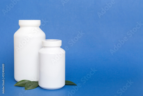 supplement pills with medicine bottle health care and medical top view. Vitamin tablets. Top view mockup bottle for pills and vitamins with green leaves, natural organic bio supplement, copy space