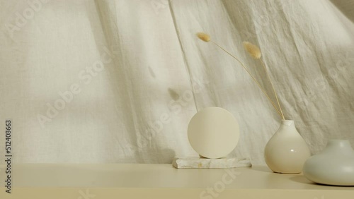 Still life with ceramic products and a flower in a vase, on the background of linen fabric and sunlight