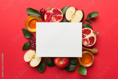 Flat lay composition with Blank flyer poster and symbols jewish Rosh Hashanah holiday attributes on colored background, New Year holiday Traditional. Top view with copy space mock up