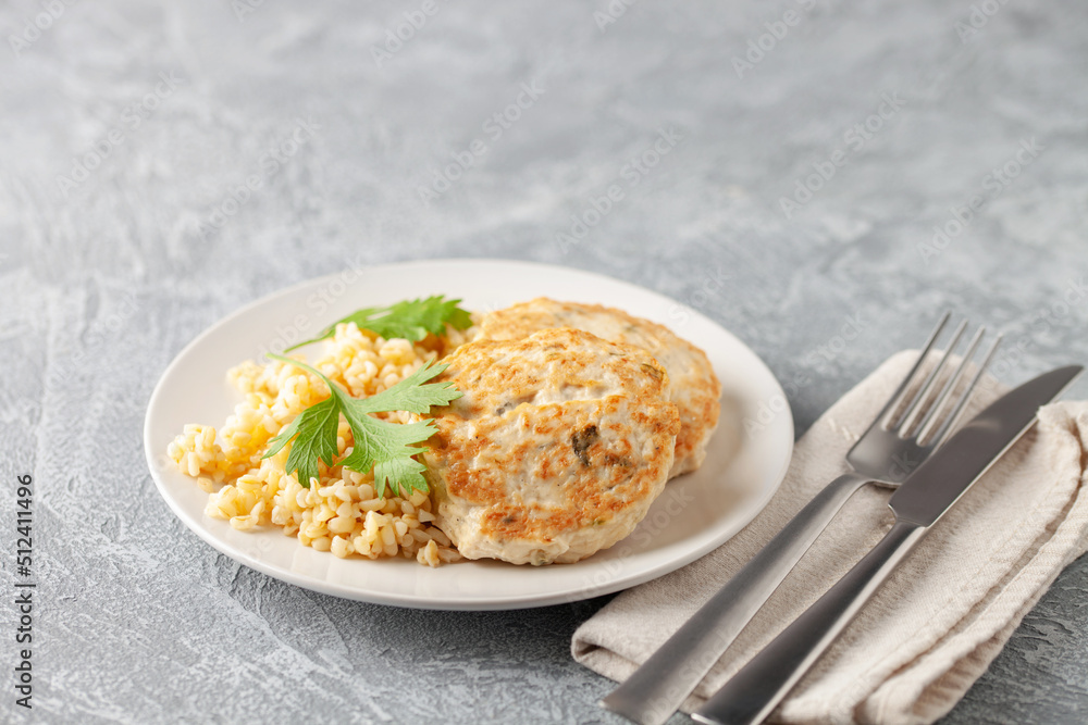 Chicken or vegetable cutlets with a side dish of bulgur in a plate on the table. Diet nutrition Chicken or vegetable cutlets with a side dish of bulgur in a plate on the table. Diet nutrition