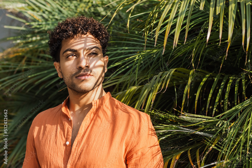 Portrait of a hispanic man on palm leaves background Portrait of a hispanic man on palm leaves background