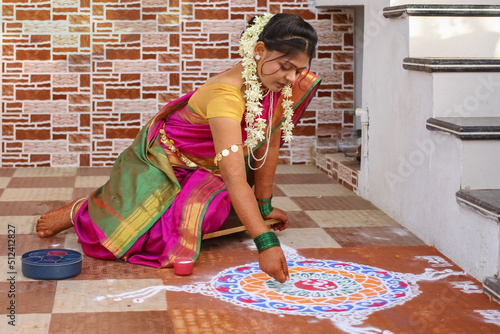 Quadro su tela hindu woman in traditional attair drawing rangoli outside home.