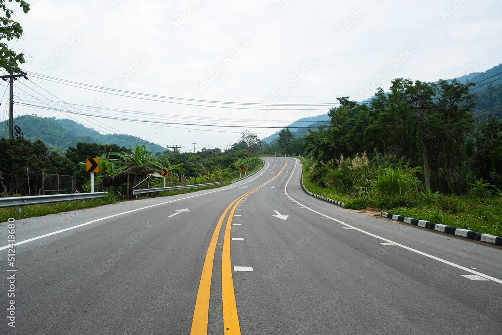 Paved road Thailand.The asphalt road on both sides of the road is covered with grass. Paved road Thailand.The asphalt road on both sides of the road is covered with grass.