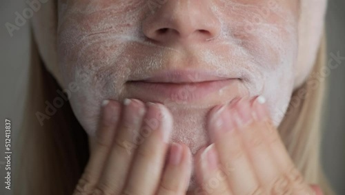 Female applies facial cleansing foam