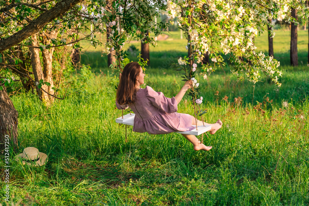 custom made wallpaper toronto digitalA brunette woman in a purple dress enjoys swinging on a rope swing in an apple orchard at sunset