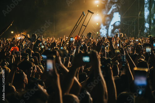 People in a crowd of a music concert using their smartphones and someone holding Fototapet