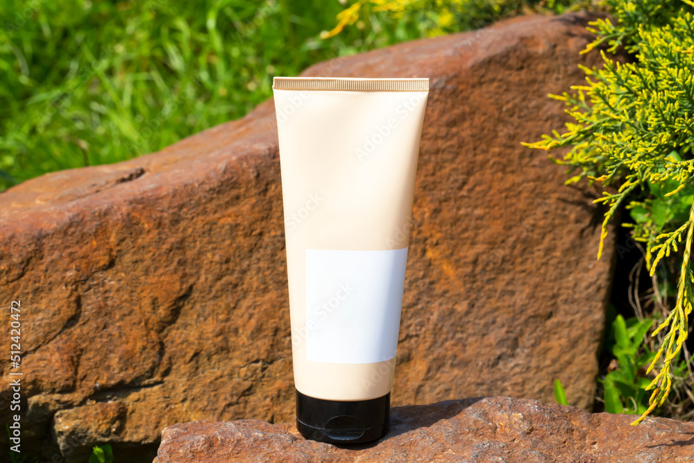 Cosmetic tube among stones and plants Cosmetic tube among stones and plants