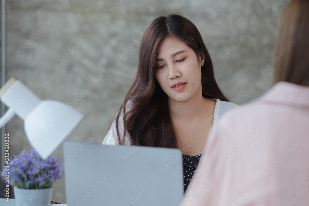 Two beautiful Asian women are meeting together in a company meeting room, meeting to discuss plans to develop the business to grow and follow the business plan. Business meeting idea. Two beautiful Asian women are meeting together in a company meeting room, meeting to discuss plans to develop the business to grow and follow the business plan. Business meeting idea.
