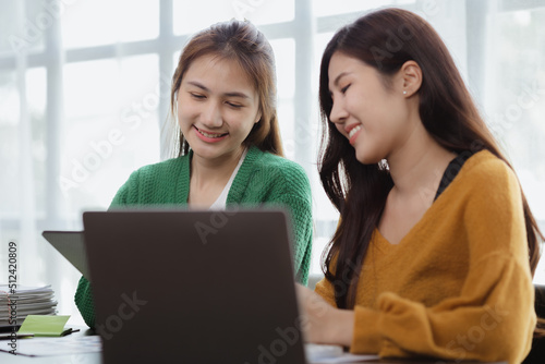 Two women sitting through white papers and talking, two business women discussing brainstorming and planning operations, form a partnership to form a startup company. Management of startup company.