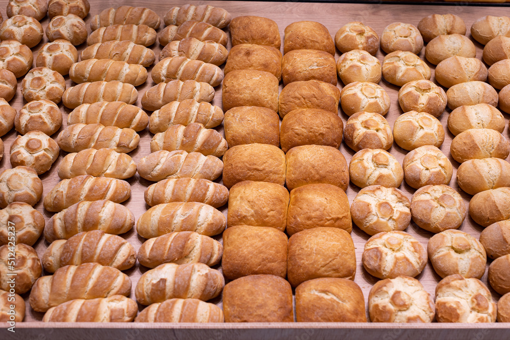 Various Types of Bread Buns displayed Orderly on Top of a Wooden Display Stand from an Italian Bakery