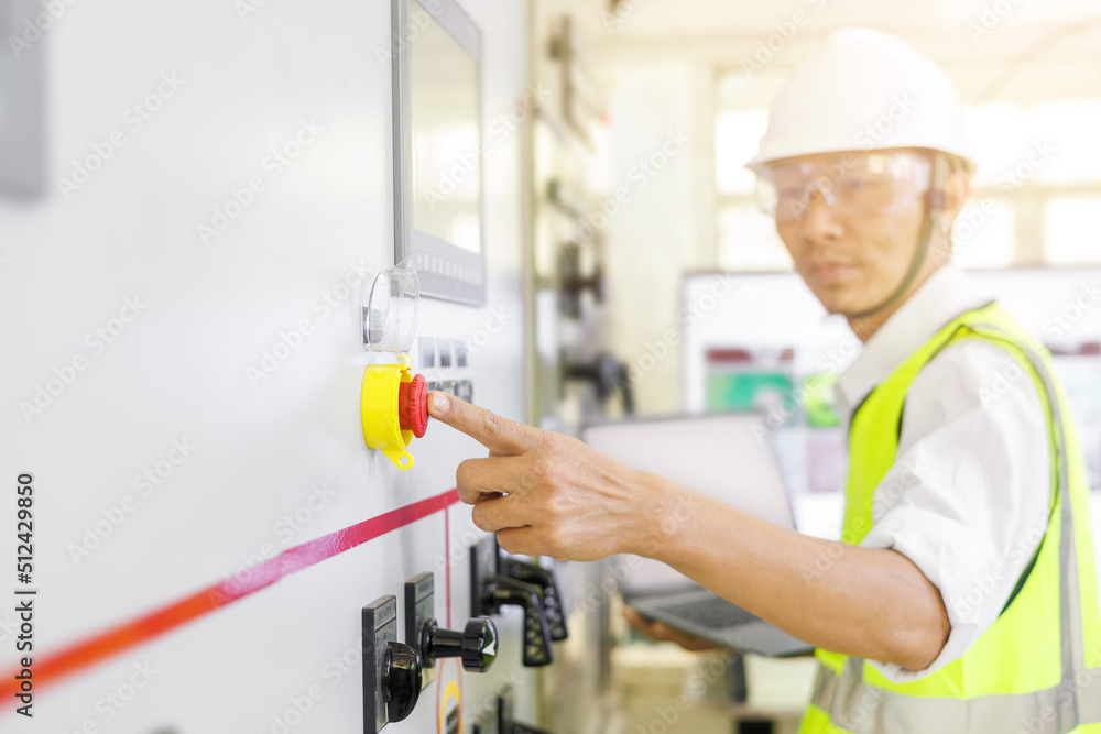 Electrical engineer or repairman was about to press the emergency stop button to inspecting the electrical system in a factory. Electrical engineer or repairman was about to press the emergency stop button to inspecting the electrical system in a factory.