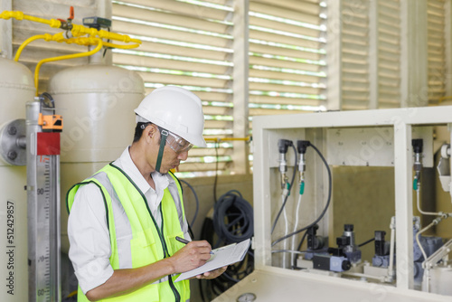 Electrical engineer holding document board to inspecting the electrical system in a factory, energy concept.