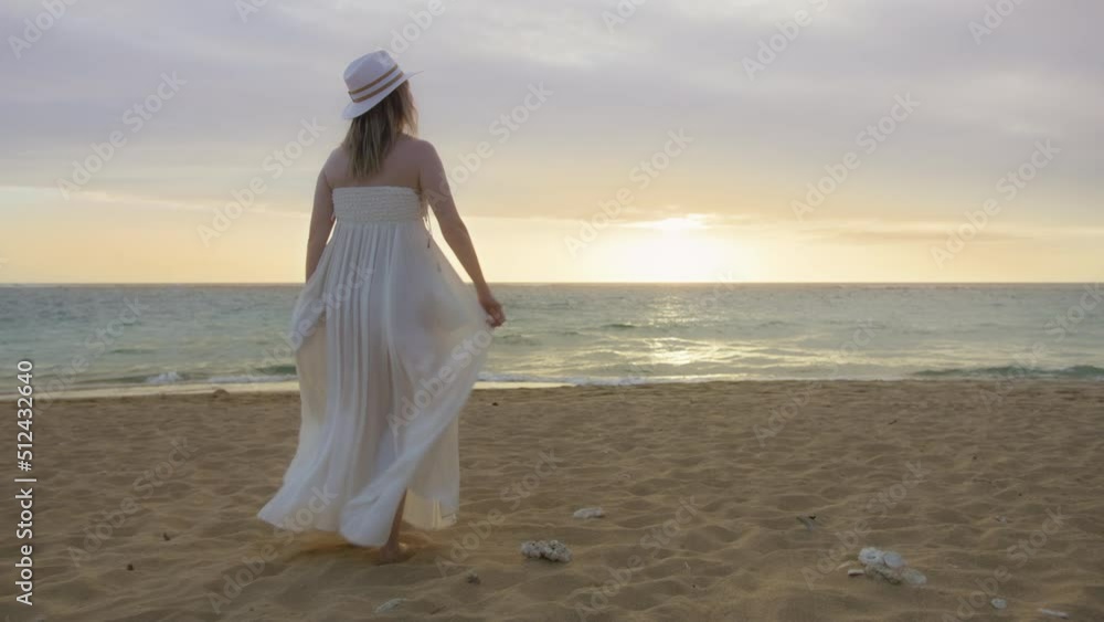 People on ocean beach. Happy female silhouette walking at golden sunset. Happy bride at dream wedding concept. Back view of woman rising hands up in the air enjoying scenic sunset above ocean Hawaii People on ocean beach. Happy female silhouette walking at golden sunset. Happy bride at dream wedding concept. Back view of woman rising hands up in the air enjoying scenic sunset above ocean Hawaii