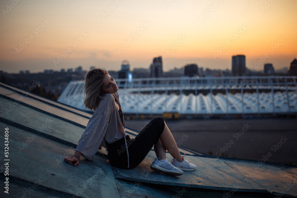 Young woman posing in the roof at sunset, freedom city atmosphere. People, lifestyle, relaxation concept. Young woman posing in the roof at sunset, freedom city atmosphere. People, lifestyle, relaxation concept.