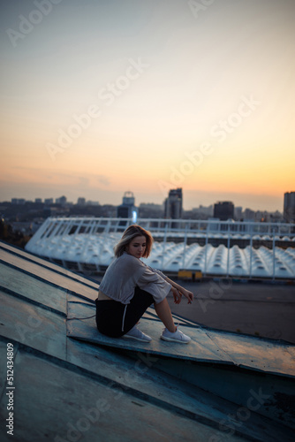 Young woman posing in the roof at sunset, freedom city atmosphere. People, lifestyle, relaxation concept.