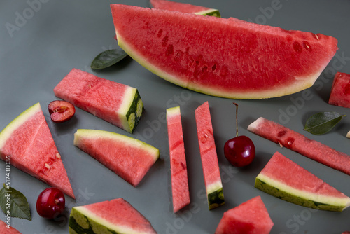 Beautiful pattern with fresh watermelon slice and cherries on green background.