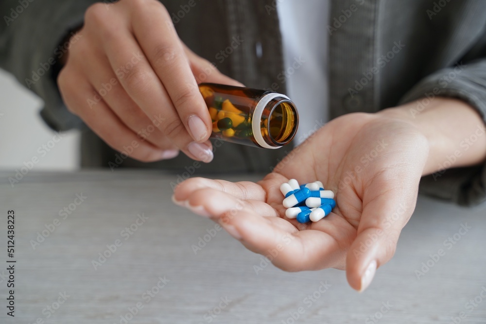 Woman pour pills into palm to take dietary supplements, vitamins or medicines. Health care, wellness Woman pour pills into palm to take dietary supplements, vitamins or medicines. Health care, wellness