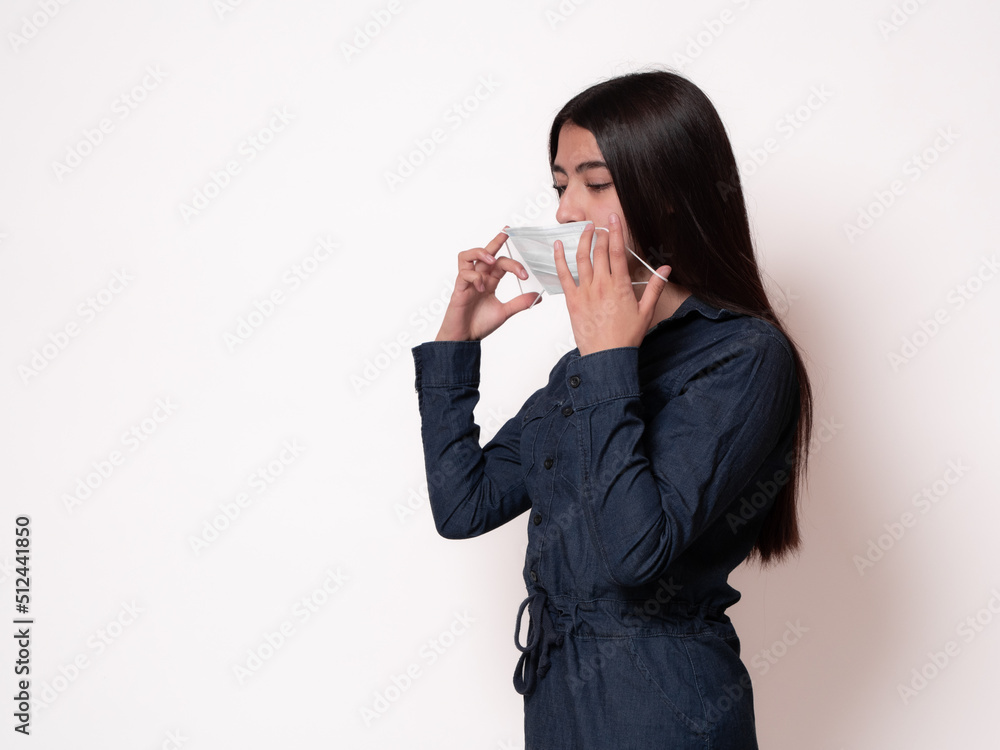 portrait of black-haired latina girl putting on surgical mask, isolated on white background portrait of black-haired latina girl putting on surgical mask, isolated on white background
