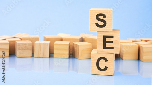 SEC. wooden cubes. blocks lie on a black background. stacks with coins. inscription on the cubes is reflected from the surface of the table. selective focus. SEC - Securities and Exchange Commission