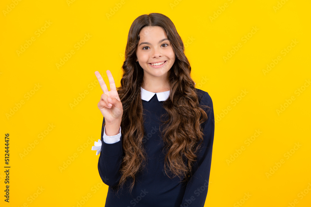 Portrait of funny cheerful teenager child girl showing v-sign isolated over yellow background. Portrait of funny cheerful teenager child girl showing v-sign isolated over yellow background.