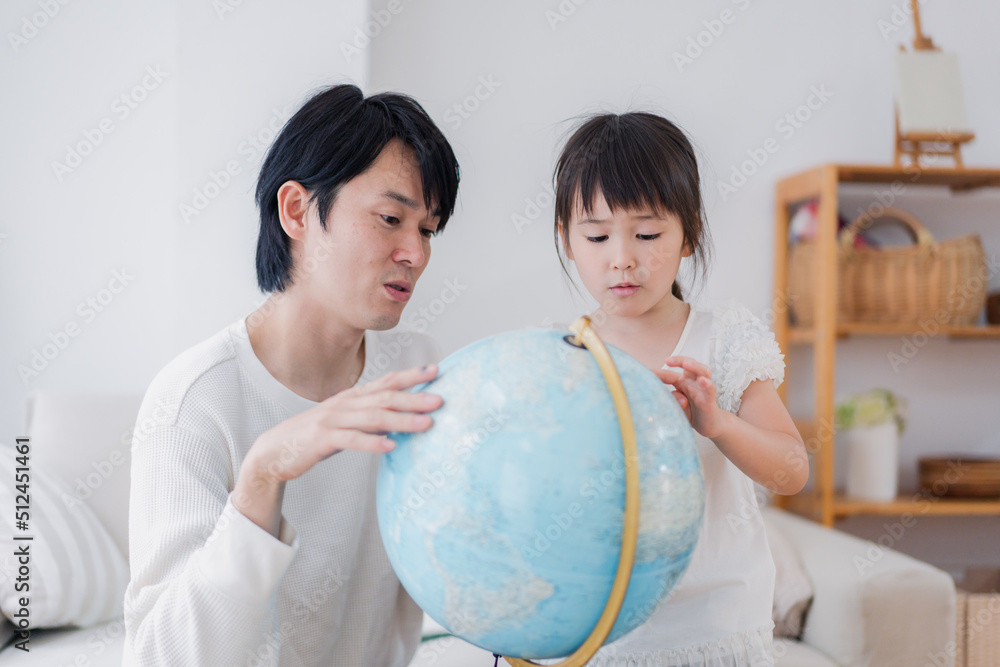 パパと地球儀を使って勉強する家族