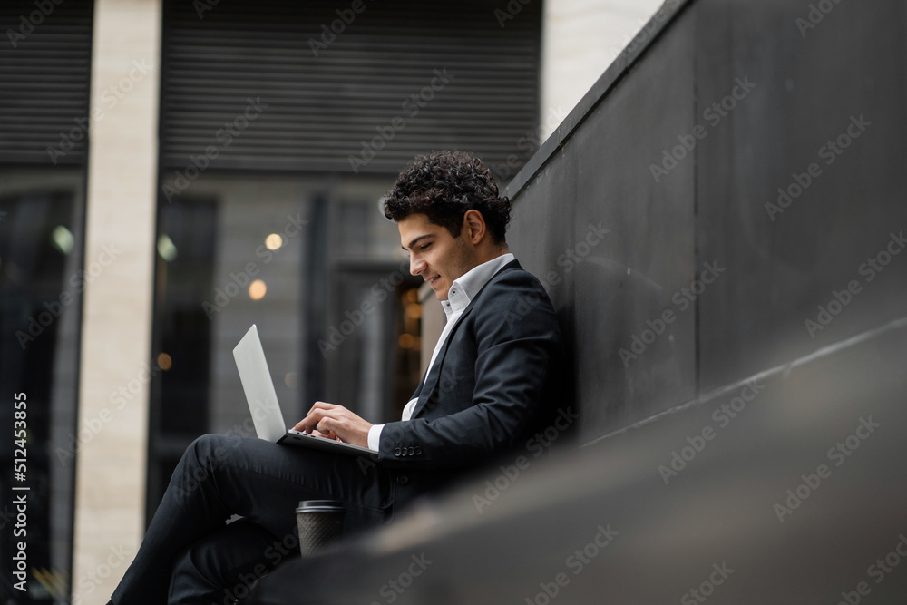 Using a laptop, a financier goes to a new office, a man in a business suit, a happy employee Using a laptop, a financier goes to a new office, a man in a business suit, a happy employee