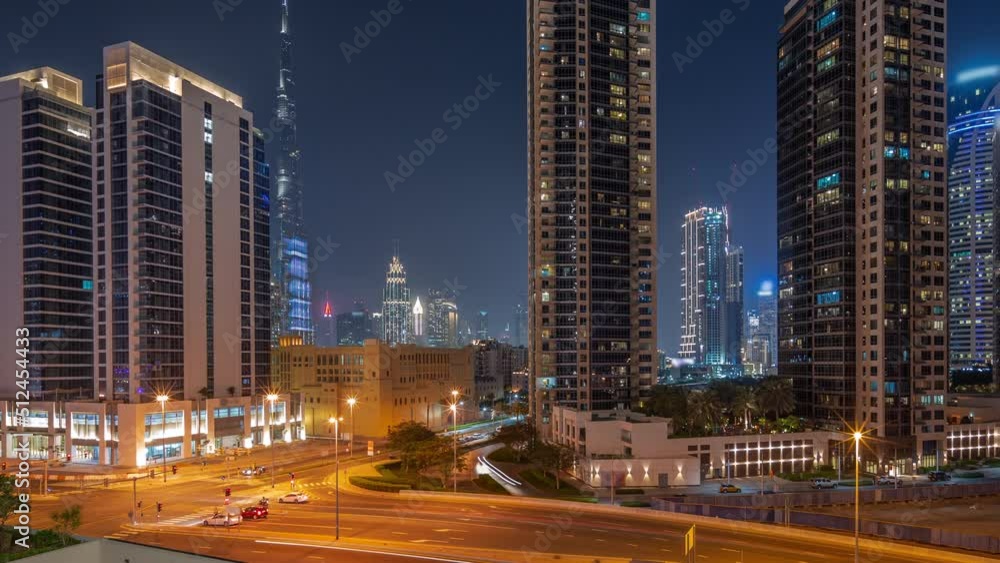 Aerial panoramic view to Dubai downtown and difc skyscrapers with busy traffic on intersection in Business bay district night timelapse. Towers with illuminated windows Aerial panoramic view to Dubai downtown and difc skyscrapers with busy traffic on intersection in Business bay district night timelapse. Towers with illuminated windows
