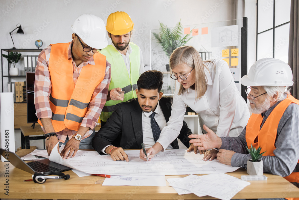 Indian man in suit presenting new construction project to colleagues in ...