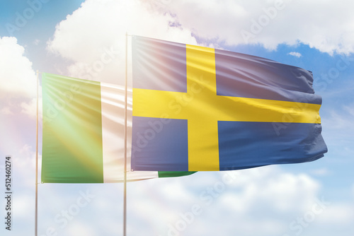 Sunny blue sky and flags of sweden and nigeria