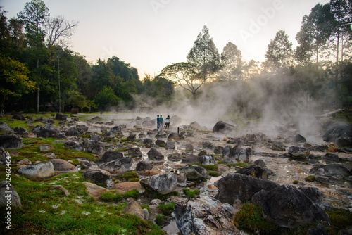 Hot springs and fog in with sunlight at morning Sunrise above hot spring nature background, Hot springs in Chae Son National Park, Lampang, Thailand.. photo