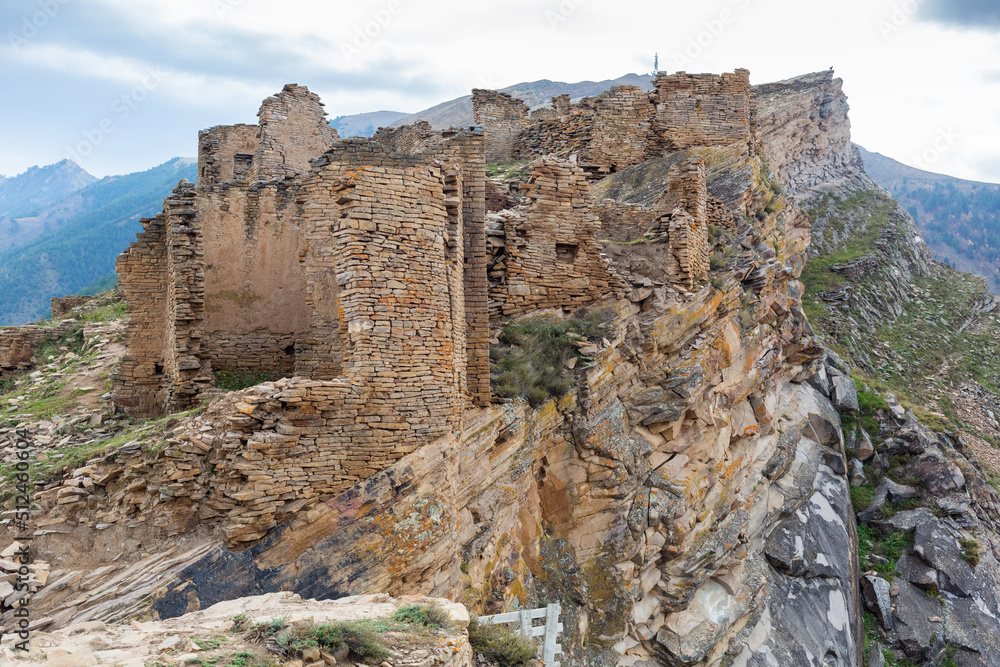 Old stone houses in Goor village, Dagestan, Russia. Ancient houses on ledges of rocks. Ruins of the abandoned village. Panoramic view of the ancient Goor settlement among the mountains