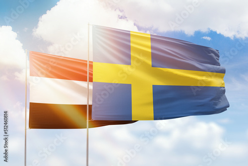 Sunny blue sky and flags of sweden and yemen