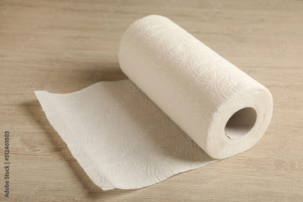 Fototapeta premium Roll of paper towels on wooden table, closeup