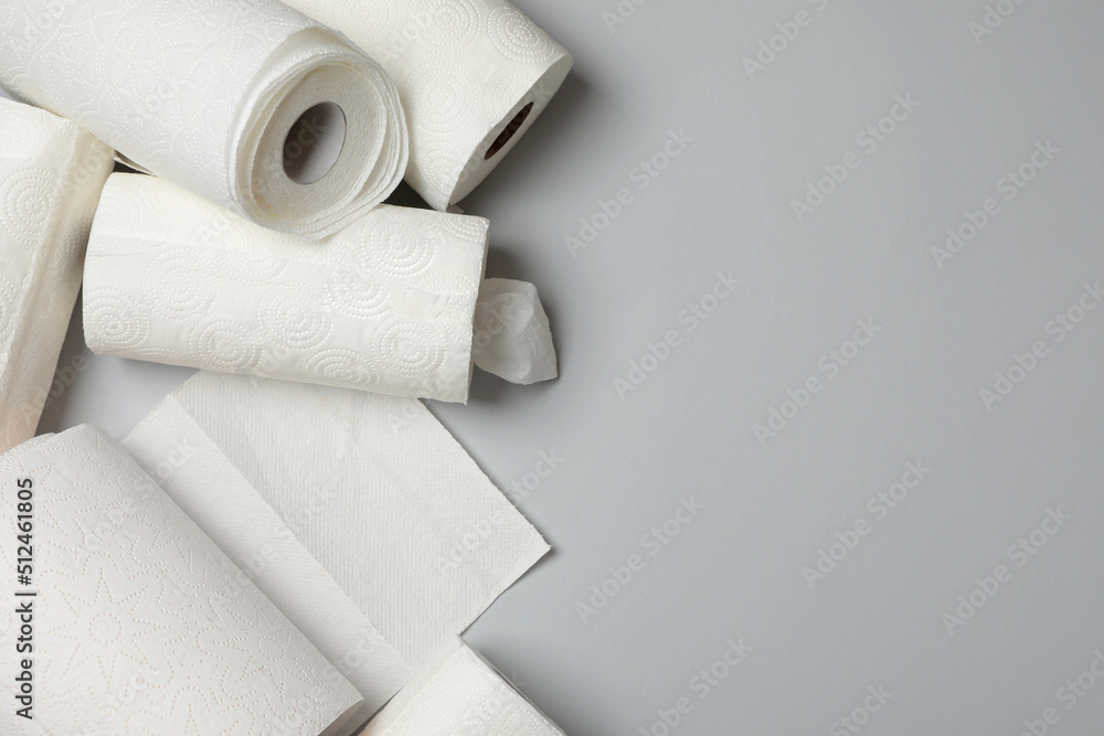 Fototapeta premium Many rolls of paper towels on grey background, flat lay. Space for text