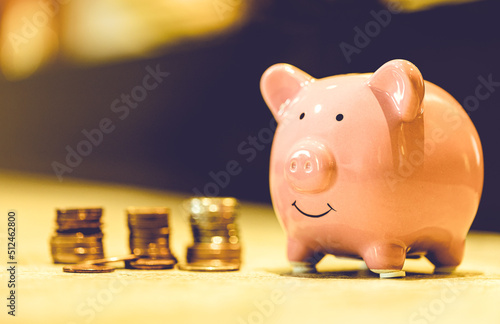 Um cofrinho com pilhas de moedas sobre uma bancada. Conceitos de finança e economia. photo