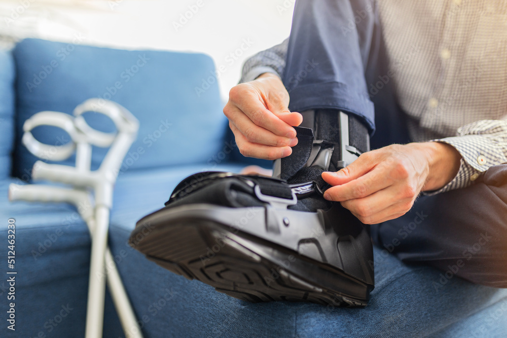 Man with walking brace on the sofa Ankle foot orthosis close-up.