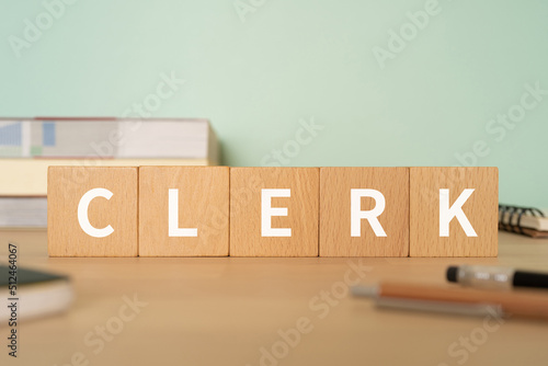 Foto 事務員・店員のイメージ｜「CLERK」と書かれたブロックが置かれたデスク