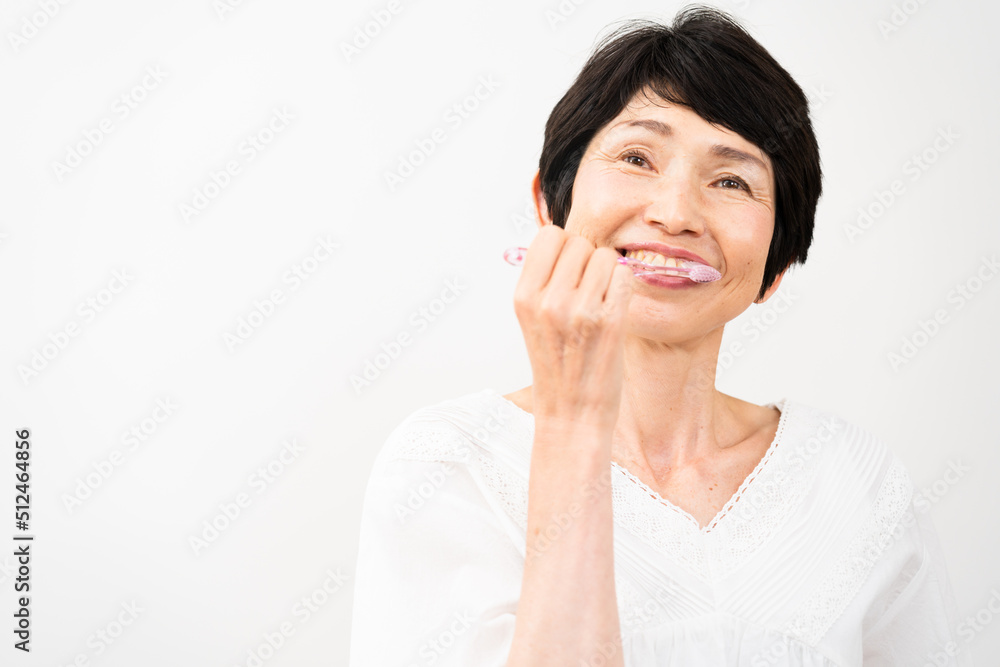 オーラルケアイメージ　ミドル女性が歯を磨いている