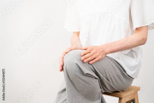 健康イメージ　膝をさするミドル女性 © aijiro