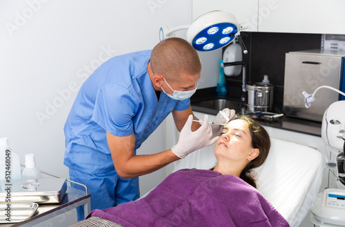 Young woman getting face skin rejuvenation treatments at beautician office
