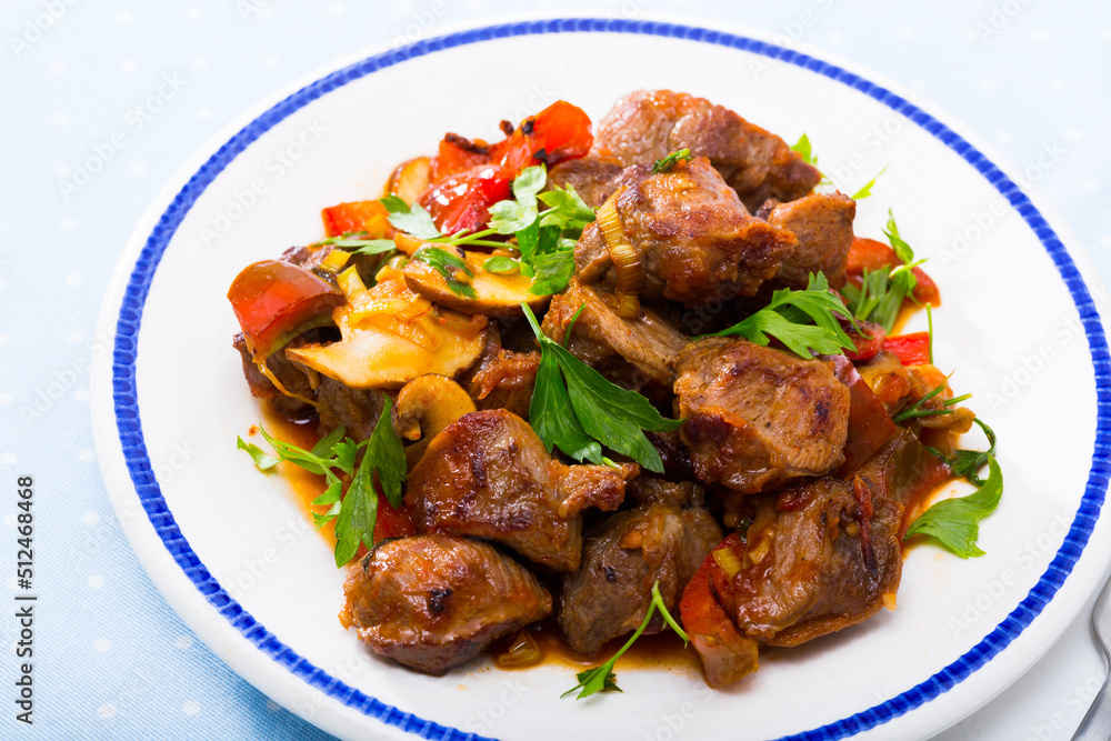 Traditional Bulgarian Kavarma - stewed marinaded meat with vegetables and mushrooms with greens