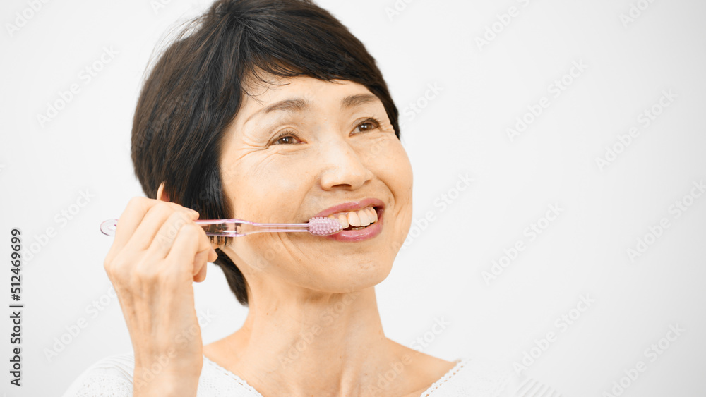 オーラルケアイメージ　ミドル女性が歯を磨いている