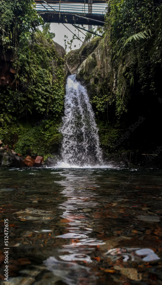a small waterfall that irrigates a river in a valley a small waterfall that irrigates a river in a valley