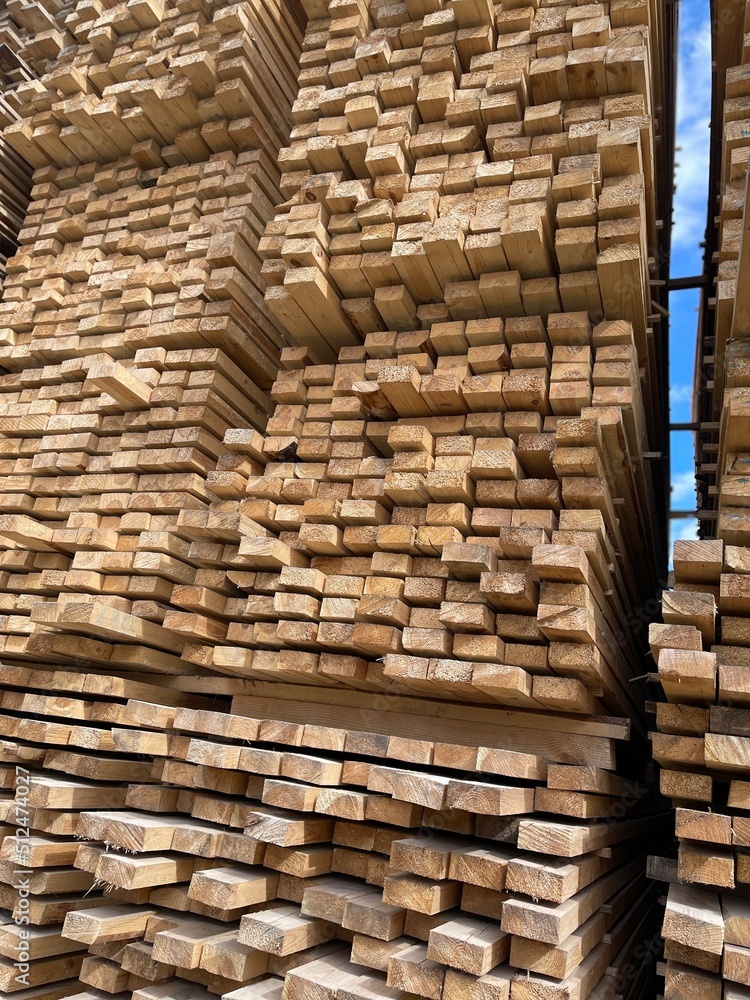 Wooden boards, lumber, industrial wood, timber. Pine wood timber stack of natural rough wooden boards on building site. Industrial timber building materials Wooden boards, lumber, industrial wood, timber. Pine wood timber stack of natural rough wooden boards on building site. Industrial timber building materials