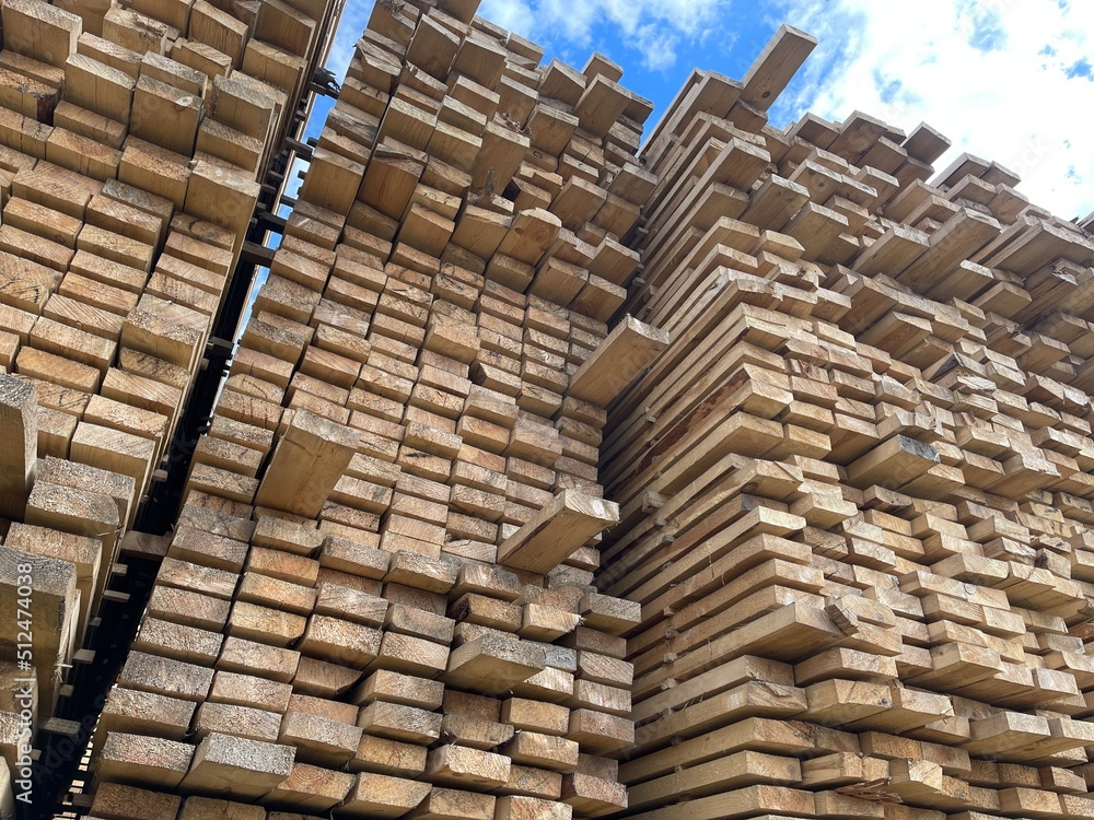 Wooden boards, lumber, industrial wood, timber. Pine wood timber stack of natural rough wooden boards on building site. Industrial timber building materials Wooden boards, lumber, industrial wood, timber. Pine wood timber stack of natural rough wooden boards on building site. Industrial timber building materials