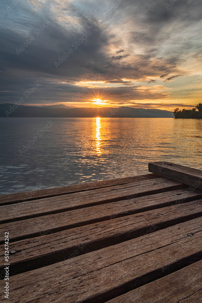 selective focus of wooden pier beach sunrise at Matano beach, south Sulawesi Indonesia