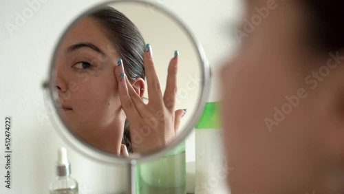 Close-up of pretty teenager girl enjoying morning procedures at home. looking in the mirror. Rejuvenation treatment. Facial skincare. Concept of skincare, cosmetics. 4k footage