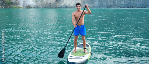 Young man using paddle boar...
